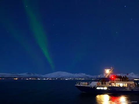 Aurora boreal sobre el fiord vista des del vaixell del creuer de Tromsø