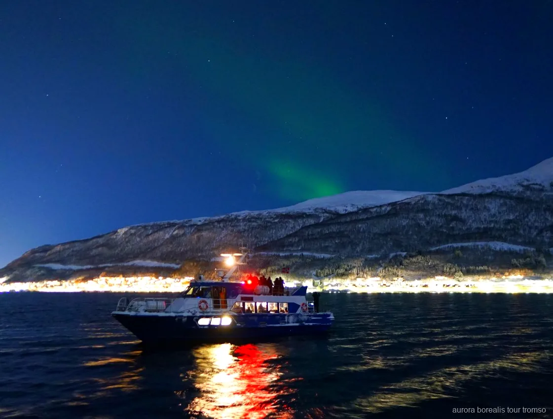 Tripulant ajudant un passatger a ajustar la càmera al creuer de Tromsø