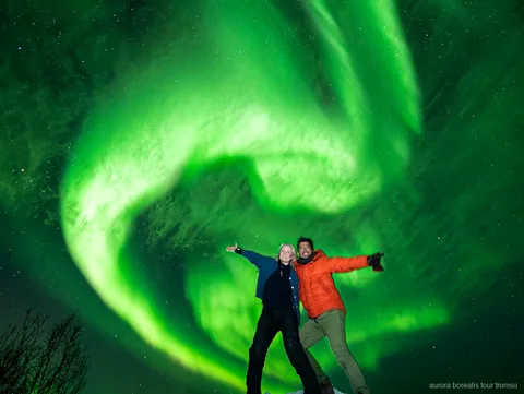 Familiegerunde minibustour groep kijkt naar het noorderlicht bij Tromso
