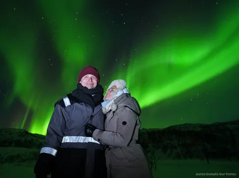 Groep op de Tromso onbeperkte noorderlichtjacht kijkt naar het noorderlicht
